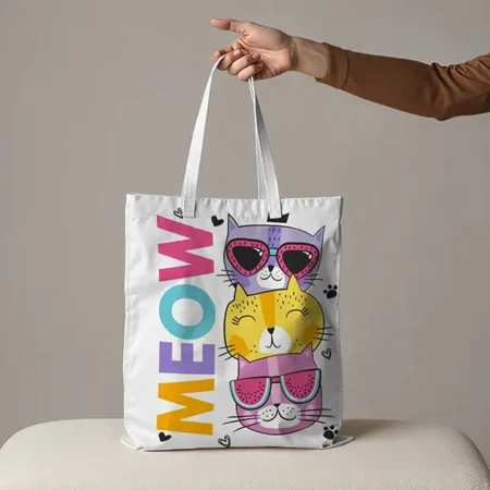 A white tote bag with a cats