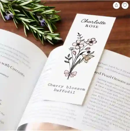 A personalized white bookmark with a simple black line art drawing of flowers and space for custom names at the top and bottom.